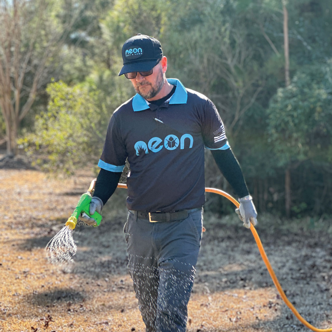 Neon technician applying a lawn treatment