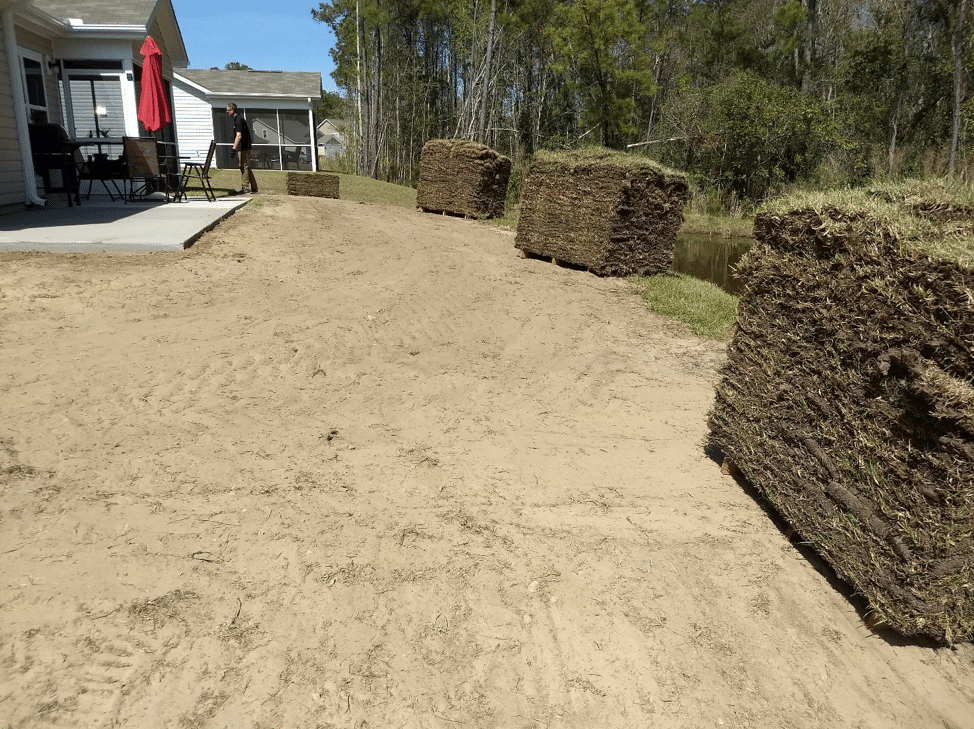 Sod pallets staged for installation on a graded lot