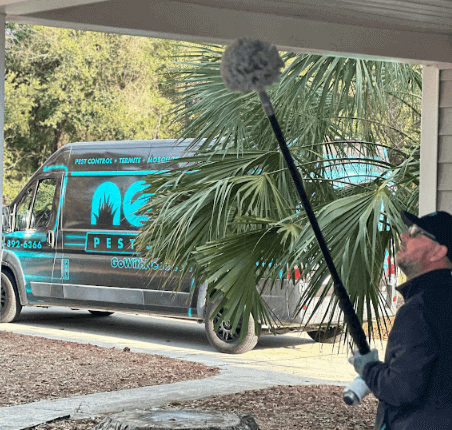 A Neon Pest and Lawn employee cleans a house with a broom, ensuring a pest-free environment for the client.