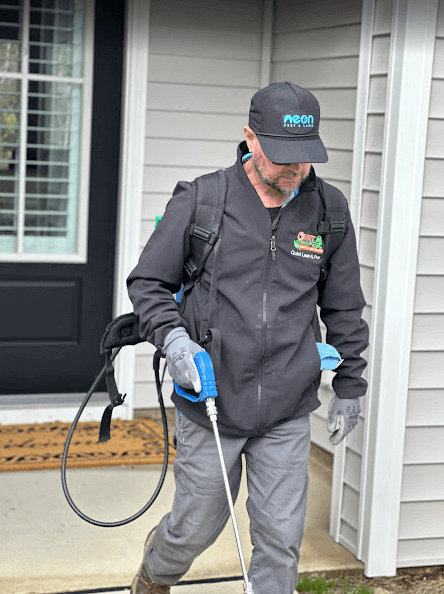 A man in a black jacket and hat operates a vacuum cleaner