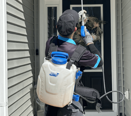 A man wearing a backpack sprayer