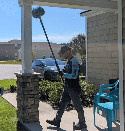 An employee of Neon Pest and Lawn sweeps away bees
