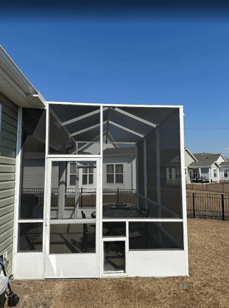 Screened in porch featuring a table and chairs